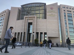 People walk to the Justice Palace as a trial against Metin Topuz, a Turkish employee of the United States Consulate in Istanbul charged with espionage and attempting to overthrow the Turkish government, began in Istanbul, Tuesday, March 26, 2019. Topuz, a translator and fixer for the Drug Enforcement Agency at the consulate, will have his first hearing Tuesday. He has been in pre-trial detention since October 2017.