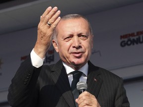 Turkey's President Recep Tayyip Erdogan salutes the supporters of his ruling Justice and Development Party during a rally in Kocaeli, Turkey, Tuesday, March 19, 2019. Ignoring widespread criticism, Erdogan on Tuesday again showed excerpts of a video taken by the attacker who killed 50 people in mosques in New Zealand, to denounce rising hatred and prejudice against Islam. (Presidential Press Service via AP, Pool)