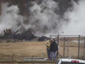 FILE - In this Jan. 17, 2019 file photo, staff from the Arkansas Department of Environmental Quality install a meteorological station to record wind speed and direction at the former stump dump site in Bella Vista, Ark. The underground fire at the illegal dumping site in northwest Arkansas has been smoldering for at least seven months, sending noxious smoke throughout the community, with costs to extinguish it estimated in the tens of millions. The fire, which started in July is beneath dozens of feet of waste and dirt in a former dump intended for tree limbs and stumps.