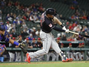 Cleveland Indians Eric Stamets (66) swings for a grand slam in front of Texas Rangers catcher Jeff Mathis (2) during the fourth inning of an exhibition baseball game in Arlington, Texas, Monday, March 25, 2019.