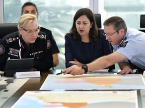 In this March 19, 2019, photo, Queensland Fire and Emergency Services Commissioner, Katarina Carroll (left), Queensland Premier Annastacia Palaszczuk (centre) and Queensland Police Deputy Commissioner Bob Gee (right) are seen during a meeting of the Queensland Disaster Management Committee discussing the approaching cyclone at the Emergency Services Complex in Brisbane.