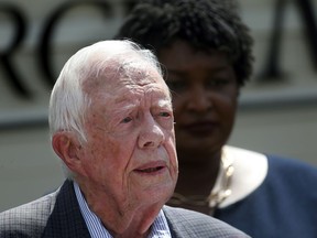 FILE- In this Sept. 18, 2018 file photo, former President Jimmy Carter speaks as Democratic gubernatorial candidate Stacey Abrams listens during a news conference to announce her rural health care plan, in Plains, Ga. Carter is now the longest-living president in American history. The 39th president on Friday, March 15, 2019, reached the age of 94 years, 172 days - one day beyond the lifespan of George H.W. Bush, who died in November.