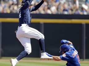 San Diego Padres shortstop Fernando Tatis Jr., left, leaps out of the way as Chicago Cubs' Mark Zagunis slides safely into second base with a stolen base during the fourth inning of a spring training baseball game Sunday, March 24, 2019, in Peoria, Ariz.