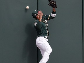 Oakland Athletics' Ramon Laureano cannot make the catch on an RBI-double by San Diego Padres' Josh Naylor during the third inning of a spring training baseball game, Friday, March 8, 2019, in Mesa, Ariz.
