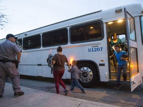 FILE - In this May 28, 2014 file photo, migrants are released from ICE custody at a Greyhound Bus station in Phoenix. Greyhound is no longer allowing immigration authorities to drop off families inside bus stations, forcing them to wait outside until they have a ticket. U.S. Immigration and Customs Enforcement agency confirmed Friday, March 15, 2019, that it had been asked to drop migrants off outside the facility.