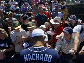 San Diego Padres' Manny Machado signs autographs prior to the team's spring training baseball game against the Los Angeles Angels on Sunday, March 17, 2019, in Peoria, Ariz.