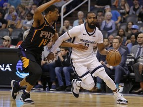 Memphis Grizzlies guard Mike Conley, right, drives past Phoenix Suns guard De'Anthony Melton, left, in the first half during an NBA basketball game, Saturday, March 30, 2019, in Phoenix.