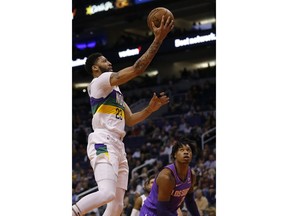 New Orleans Pelicans forward Anthony Davis (23) drives past Phoenix Suns guard Elie Okobo in the first half during an NBA basketball game, Friday, March 1, 2019, in Phoenix.