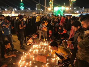 Shiite Muslim worshippers light candles as they pray for the victims of a sunken ferry, outside the golden-domed Shiite shrine of Imam Moussa al-Kadhim, in Baghdad, Iraq, Friday, March 22, 2019. A ferry overloaded with people celebrating the Kurdish new year sank in the Tigris River near the Iraqi city of Mosul on Thursday, killing dozens of people, mostly women and children, officials said.