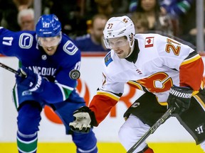 Calgary Flames' Austin Czarnik (27) catches the puck near Vancouver Canucks' Josh Leivo (17) during third period NHL hockey action in Vancouver on Saturday, March 23, 2019.