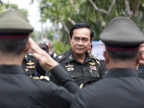 FILE - In this Thursday, Aug. 21, 2014, file photo, Thailand's Prime Minister Prayuth Chan-ocha, center, arrives for an anniversary ceremony for the 21st infantry regiment, Queen's Guard, in Chonburi Province, Thailand. Prayuth became prime minister in a very Thai way: He led a military coup. Now after five years of running Thailand with absolute power, he's seeking to hold on to the top job through the ballot box. The military's thinly veiled proxy party has put forward Prayuth as its nominee for prime minister after Sunday's election. But running the show in an elected government may not be as easy though since he'll no longer be able to muzzle opponents and rely on a rubberstamp legislature.