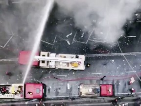 In this image made from video, firetrucks hose down a building on fire in the Banani area of Dhaka, Bangladesh, Thursday, March 28, 2019. An official in the Fire Department control room says the fire had broken out in an office building in Bangladesh's capital, and some people are feared trapped inside. (AP Photo)