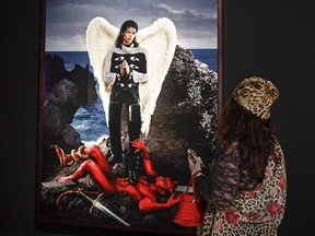 A visitor watches the picture 'Archangel Michael: And no message could have been any clearer' from US artist David LaChapelle at a preview of the exhibition 'Michael Jackson: On The Wall' at the Bundeskunsthalle museum in Bonn, Germany, Thursday, March 21, 2019. The exhibition around the controversial iconic pop idol is open until July 14.