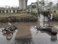 Destroyed motorcycles are left in a flooded street in Sao Paulo, Brazil, Monday March 11, 2019.