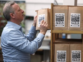 In this Monday, Feb. 25, 2019 photo, Paolo Arrigo of Seeds of Italy displays his Brexit Vegetable Growing Survival kit bags, at his company store in London. Arrigo put together 12 months' worth of easy-to-grow seed packets _ carrots, beans, lettuce, pumpkin, tomatoes _ and labelled it a Brexit Vegetable Growing Survival Kit. He has sold hundreds in a few weeks.