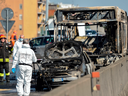 Police and firefighters work by the wreckage of a school bus that was transporting some 50 children after it was torched by the bus' driver, in San Donato Milanese on March 20, 2019.