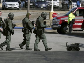 Police and a robotic device exit the Quality Inn on Thursday, March 28, 2019, in Manchester, N.H., after a standoff was resolved. Two people had barricaded themselves in a first-floor room after one man was shot and killed there Wednesday night by police after he engaged Drug Enforcement Administration agents and police.
