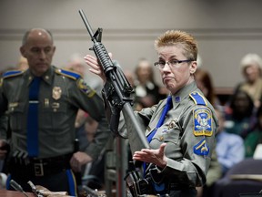 FILE - In this Jan. 28, 2013, file photo, firearms training unit Detective Barbara J. Mattson, of the Connecticut State Police, holds a Bushmaster AR-15 rifle, the same make and model used by Adam Lanza in the 2012 Sandy Hook School shooting, during a hearing at the Legislative Office Building in Hartford, Conn. The Connecticut Supreme Court is expected to rule Thursday, March 14, 2019, whether or not Remington Arms, which manufactured the rifle, can be sued for making the rifle that was used in the massacre.