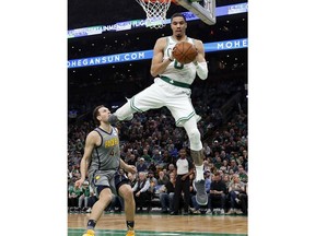 Boston Celtics' Jayson Tatum grabs a loose ball in front of Indiana Pacers' Bojan Bogdanovic during the first quarter of an NBA basketball game Friday, March 29, 2019, in Boston.