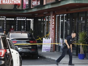 A Los Angeles Police officer walks past the taped Marathon Clothing store of Rapper Nipsey Hussle in Los Angeles, Sunday, March 31, 2019.