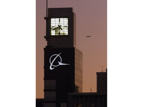 FILE - This Dec. 20, 2001 file photo shows an airplane flying past the Boeing logo on the company's headquarters in Chicago. The FAA's oversight duties are coming under greater scrutiny after deadly crashes involving Boeing 737 Max jets owned by airlines in Ethiopia and Indonesia, killing a total of 346 people. The U.S. was nearly alone in allowing the planes to keep flying until it relented on Wednesday, March 13, 2019, after getting satellite evidence showing the crashes may be linked.