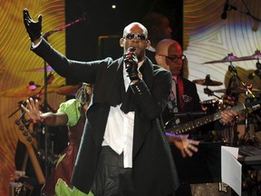 FILE - In this Jan. 25, 2014 file photo, recording artist R. Kelly performs at The 56th Annual Grammy Awards Salute to Industry Icons with Clive Davis in Beverly Hills, Calif. A Chicago judge is expected to rule on whether to let R. Kelly travel overseas to perform several concerts to help the cash-strapped singer pay legal and other bills as he faces sex-abuse charges. A hearing Friday, March 22, 2019, follows a defense motion saying the 52-year-old singer hopes to do up to five April concerts in Dubai.