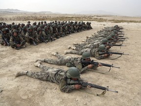 FILE - In this Oct. 31, 2018, photo, Afghan National Army soldiers carry out an exercise during a live firing at the Afghan Military Academy in Kabul, Afghanistan. Afghan officials say around 100 soldiers fled their posts and tried to cross into neighboring Turkmenistan during a weeklong battle with the Taliban, in the latest setback for the country's battered security forces. Mohammad Naser Nazari, a provincial council member in the western Badghis province, said Sunday, March 17, 2019, that the soldiers were not allowed to cross the border and their fate remains unknown.