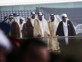 FILE - In this Feb. 19, 2017 file photo, Abu Dhabi Crown Prince Sheikh Mohammed bin Zayed Al Nahyan, third right, Dubai's ruler Sheikh Mohammed bin Rashid Al Maktoum, second right, and Sudanese President Omar al-Bashir, right, leave the International Defense Exhibition and Conference, in Abu Dhabi, United Arab Emirates. On Sunday, March 17, 2019, hundreds of Sudanese took part in anti-government protests in the capital and other cities, as the government says it has secured $300 million in loans from Emirate-based sources to address the economic crisis that triggered the unrest.
