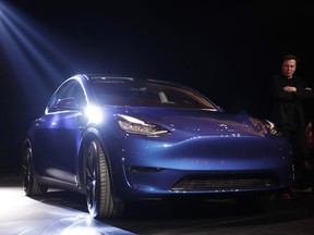 Tesla CEO Elon Musk, right, stands next to the Model Y at Tesla's design studio Thursday, March 14, 2019, in Hawthorne, Calif. The Model Y may be Tesla's most important product yet as it attempts to expand into the mainstream and generate enough cash to repay massive debts that threaten to topple the Palo Alto, Calif., company.