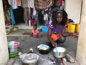 Marta Ben prepares food on a sidewalk after her home was destroyed in Beira, Mozambique, Friday March 22, 2019. There are still fears that the death toll in Mozambique could soar as floodwaters recede. The secretary-general of the International Federation of Red Cross and Red Crescent Societies says the number of deaths could be beyond the 1,000 predicted by the country's president earlier this week.