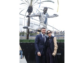 Former LA Galaxy MLS soccer midfielder David Beckham, left, and his wife Victoria pose with a statue of himself at Legends Plaza in front of Dignity Health Sports Park in Carson, Calif., Saturday, March 2, 2019.