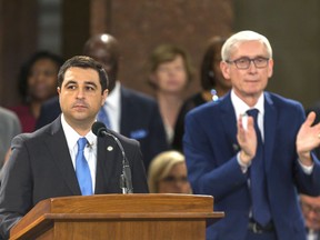 FILE - In this Jan. 7, 2019 file photo, Wisconsin Attorney General Josh Kaul speaks during his address at the inauguration of Gov. Tony Evers, right, at the state Capitol in Madison, Wis. Kaul has filed a motion to withdraw the state from an ongoing federal lawsuit seeking repeal of the Affordable Care Act. Kaul filed the motion Thursday after fellow Democrat, Evers, ordered him to withdraw Wisconsin from the lawsuit. Kaul had been blocked from taking action under a law passed by the Republican Legislature in a lame-duck session shortly before he took office.