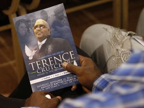 FILE - In this Sept. 24, 2016 file photo, a man holds a copy of the program for the funeral of Terence Crutcher during services to honor him in Tulsa, Okla., The Department of Justice says there is insufficient evidence to pursue federal civil rights charges against a white former Tulsa police officer who shot and killed an unarmed black man. U.S. Attorney Trent Shores on Friday, March 1, 2019,  announced the closure of the federal investigation into whether ex-Tulsa police officer Betty Shelby willfully used unreasonable force against Terence Crutcher when she shot and killed him in September 2016.