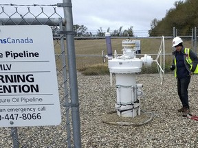 In this Oct. 11, 2016 photo provided by Samuel Jessup, climate change activist Michael Foster, of Seattle, turns an emergency shut-off valve on an oil pipeline in northeastern North Dakota. Foster was arrested and ended up spending six months in jail. The valve-turning tactic has been embraced in recent years by activists who believe fossil fuels are precipitating a global warming crisis. But the energy industry and its advocates say it amounts to domestic terrorism, and lawmakers in several states are considering stiffening penalties.