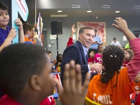 Federal Finance Minister Bill Morneau takes questions from children from the Toronto and Kiwanis Boys and Girls Club after putting on his new budget shoes for a pre-budget photo opportunity in Toronto on Thursday, March 14, 2019.