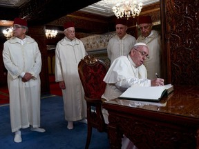 Pope Francis leaves a message in the guest book of the Mausoleum of Mohammed V in Rabat Saturday, March 30, 2019. Pope Francis has praised Morocco as a model of religious moderation and migrant welcome as he opened a quick trip to the North African kingdom. The pope says Saturday that walls and fear-mongering won't stop people from seeking a better life elsewhere. Francis met with some of Morocco's newest arrivals and assured them: "You are not the marginalized; you are at the center of the church's heart." (
