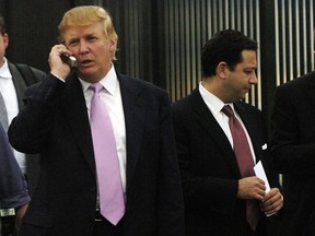 FILE - In this Sept. 14, 2005, file photo, businessman Donald Trump, left, talks on his cellphone with Felix Sater, right, outside after speaking at the Bixpo 2005 business convention at the Budweiser Events Center in Loveland, Colo. Sater, a Soviet emigre who befriended Trump over a series of development deals in the 2000s and pushed the Trump Tower Moscow project before and during the 2016 presidential campaign, has emerged as a key figure in House Democrats' investigations into Trump's Russia connections.