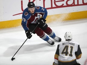 Colorado Avalanche center Nathan MacKinnon, top, looks to pass the puck as Vegas Golden Knights center Pierre-Edouard Bellemare defends during the first period of an NHL hockey game Wednesday, March 27, 2019, in Denver.
