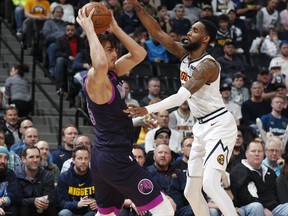Minnesota Timberwolves forward Dario Saric, left, gets trapped with the ball by Denver Nuggets guard Will Barton in the first half of an NBA basketball game, Tuesday, March 12, 2019, in Denver.
