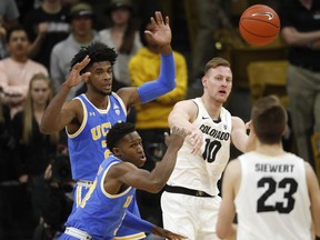 Colorado forward Alexander Strating, back, right, passes the ball to forward Lucas Siewert, front right, under defensive pressure from UCLA guards Jalen Hill, back left, and David Singleton in the first half of an NCAA college basketball game Thursday, March 7, 2019, in Boulder, Colo.