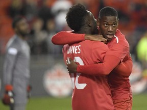 Canada's Jonathan David, right, celebrates his goal against Dominica with teammate Alphonso Davies during first half CONCACAF Nations League qualifier soccer action in Toronto on Tuesday, October 16, 2018. David is looking to add his offensive firepower to the Canadian men's team when they play French Guiana in a CONCACAF Nations League qualifier in Vancouver on Sunday.THE CANADIAN PRESS/Nathan Denette