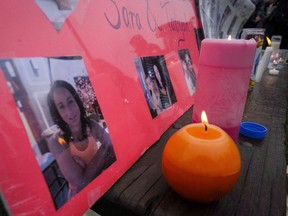 Lit candles and photographs are seen on display at a vigil for Calgary homicide victims Sara Baillie and her five-year-old daughter Taliyah Marsman, in Calgary, on July 17, 2016. A sentencing hearing is to begin today for a Calgary man convicted of killing a woman and her young daughter.