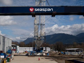 A worker walks through the Seaspan Vancouver Shipyards as the main girder of a new 300-tonne gantry crane is lifted into place in North Vancouver, B.C., on Wednesday April 2, 2014. A Vancouver shipyard is searching for answers after a fisheries science vessel that it is building for the Canadian Coast Guard, and which is already overdue, ran into a breakwater near Victoria.