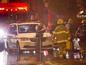 Police and fireman work at the rear of an auditorium where a gunman shot and killed at least one person during the PQ victory rally on September 5, 2012, in Montreal.