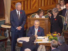 New Brunswick Progressive Conservative MLA Ernie Steeves, centre, is sworn in as Minister of Finance, and President of the Treasury Board at the New Brunswick Legislature in Fredericton on Friday, Nov. 9, 2018. New Brunswick's minority government will hand down its first budget Tuesday, saying it will offer the hard decisions needed to balance the province's finances.