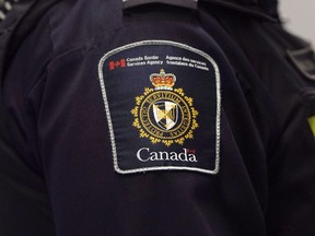 A Canadian Border Services agent stands watch at Pearson International Airport in Toronto on Tuesday, December 8, 2015. Travellers, immigration detainees and others who feel they were mistreated by Canada's border agency would be able to complain to an independent body under a new measure included in the federal budget.