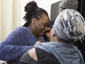 Johanne Coriolan, left, a family member of Pierre Coriolan, is consoled by activsts Wil Prosper and Maguy Metellus following a news conference in Montreal, Wednesday, February 7, 2018. Quebec's Crown prosecutors' office say it won't press charges against the Montreal police officers who fatally shot a black man during a 2017 intervention.THE CANADIAN PRESS/Graham Hughes