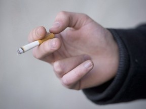 JTI-Macdonald Corp. says it was granted creditor protection following a Quebec Court of Appeal's decision upholding a landmark judgment ordering three companies to pay billions of dollars in damages to Quebec smokers. A smoker is seen holding his cigarette during a smoke break outside a building in North Vancouver, B.C., Monday, Jan. 20, 2014.