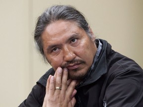 Chief Allan Adam of the Athabasca Chipewyan First Nation listens as Archbishop Desmond Tutu speaks during a press conference in Fort McMurray, Alta. on Friday May 30, 2014.