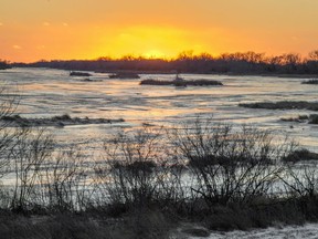 In this Feb. 7, 2019 photo, the sun sets behind the ice-covered Platte River in Columbus, Neb. Mentioning climate change can kill a conversation. But a new Alberta project is using the topic to start one - and has shown people from geologists to farmers to environmentalists they have more in common than they thought.